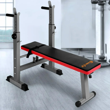 Adjustable weight bench with black padding and red trim in a bright home gym setting
