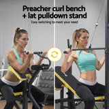 Woman using a preacher curl bench and lat pulldown stand in a gym setting