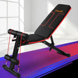 Adjustable weight bench with red resistance bands in a bright indoor gym setting