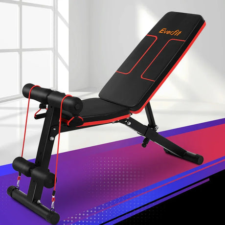 Adjustable weight bench with red resistance bands in a bright indoor gym setting