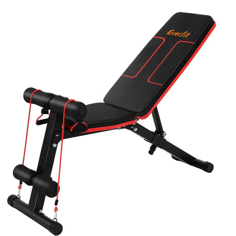 Adjustable weight bench with black and red padding, resistance bands attached.