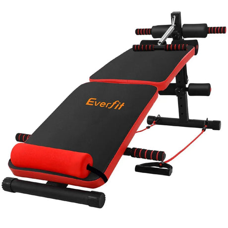 Adjustable sit up bench with black and red padding, resistance bands, and foam rollers