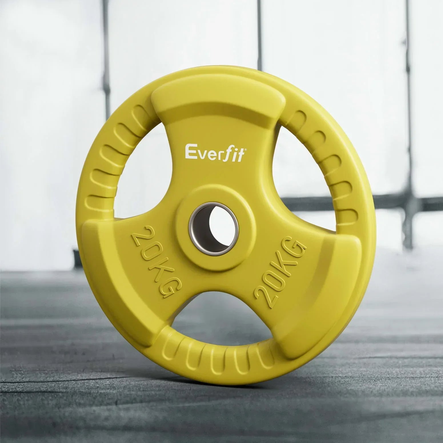 Yellow 20kg Everfit weight plate with hand grips on gym floor