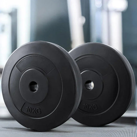 Pair of 10kg black weight plates on gym floor, fitness equipment close-up