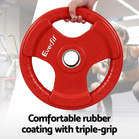 Red 15kg triple-grip rubber weight plate held in gym setting, fitness equipment