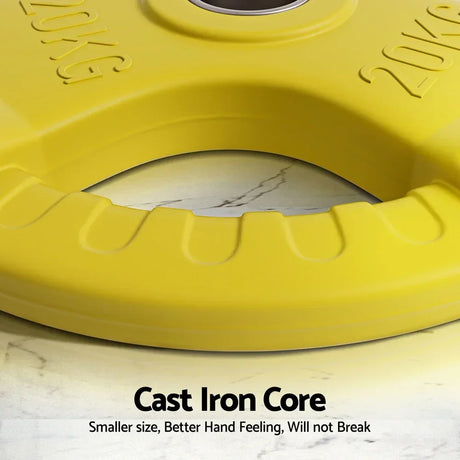 Close-up of yellow 20kg cast iron weight plate with grip handle on marble surface.