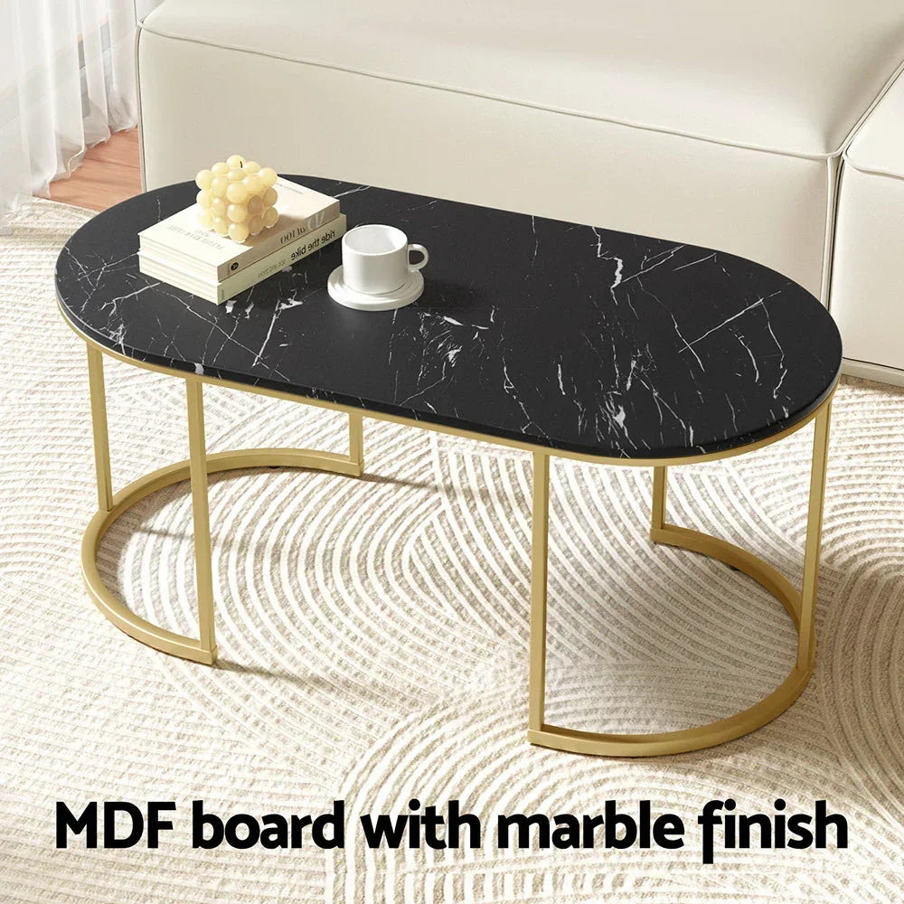 Oval black marble finish coffee table with gold legs in modern living room setting