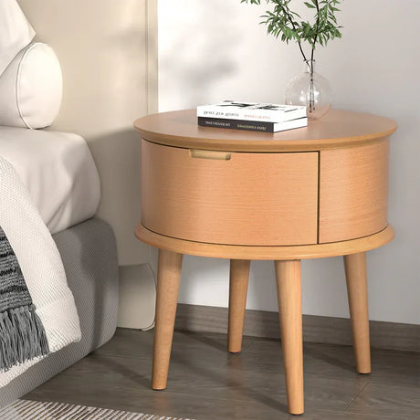Round wooden bedside table with storage, books and plant decor, modern bedroom furniture