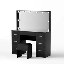 Black makeup vanity table with lighted mirror, drawers, and matching stool