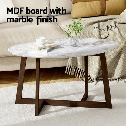 Oval coffee table with marble finish MDF top and wooden legs in modern living room.