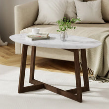 Modern oval marble coffee table with dark wood legs in living room setting