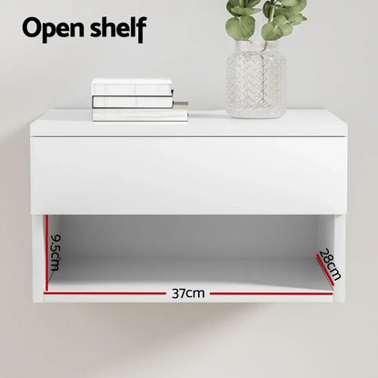 White floating wall shelf with open compartment, labeled dimensions 37cm x 28cm x 9.5cm, books and plant decor on top.