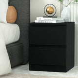 Modern black bedside table with two drawers, lamp, books, and white vase in bedroom