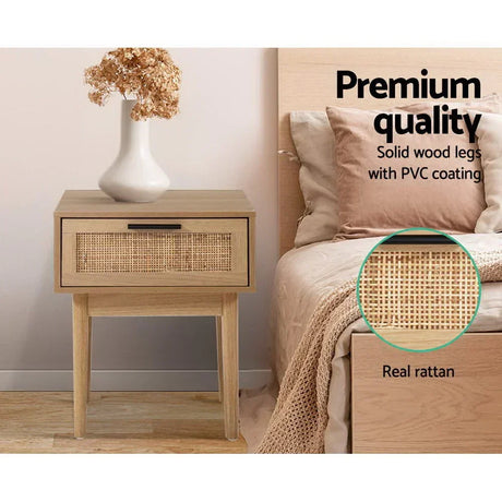 Wooden bedside table with rattan drawer, solid wood legs, next to bed in modern bedroom.