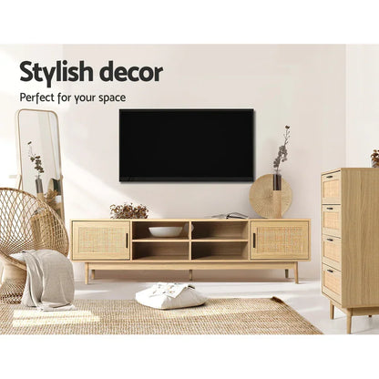 Modern living room with wooden TV unit, rattan chair, chest of drawers, and wall-mounted TV.