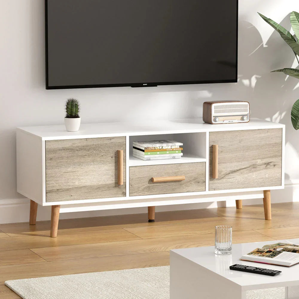 Modern white and wood TV unit with storage, books, and decor in a living room setting