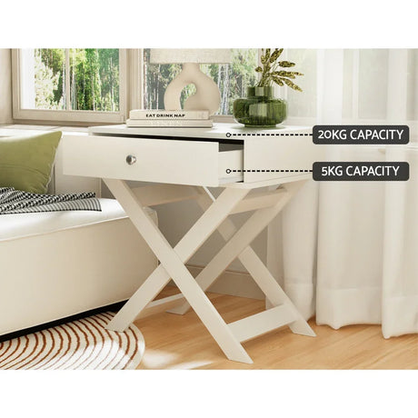 White wooden bedside table with X-legs, open drawer, indoor setting, 20kg top, 5kg drawer capacity