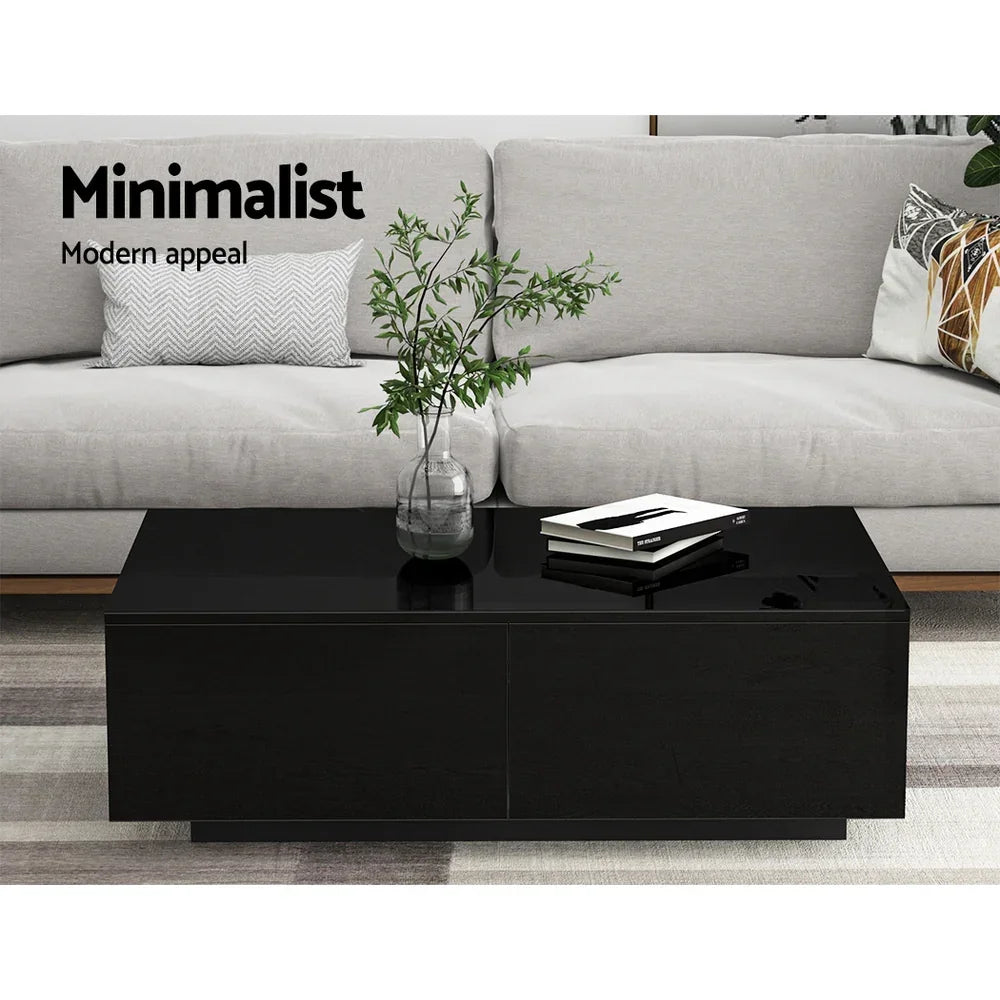 Black minimalist coffee table with glass vase and books in modern living room setting