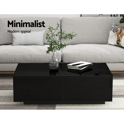 Black minimalist coffee table with glass vase and books in modern living room setting