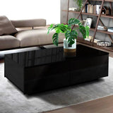Modern black coffee table with glossy finish and potted plant in a stylish living room