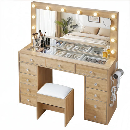 Wooden makeup vanity table with mirror lights, storage drawers, stool, and beauty accessories