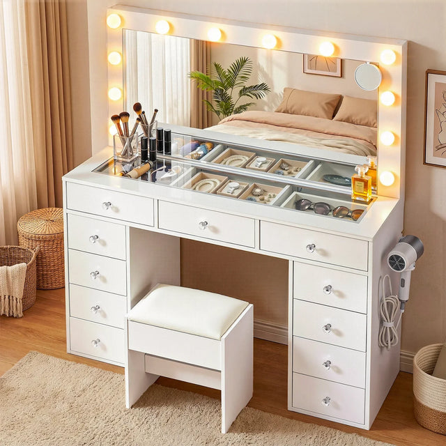 White vanity table with lighted mirror, makeup organizers, and cushioned stool in a bedroom.