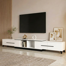 Modern white TV stand with black accents, holding decor and books, in a stylish living room
