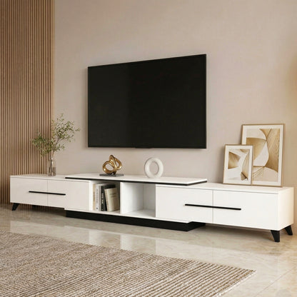 Modern white TV stand with black accents, holding decor and books, in a stylish living room