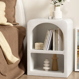 Modern white nightstand with open shelves, vases, books, and minimalist decor beside bed