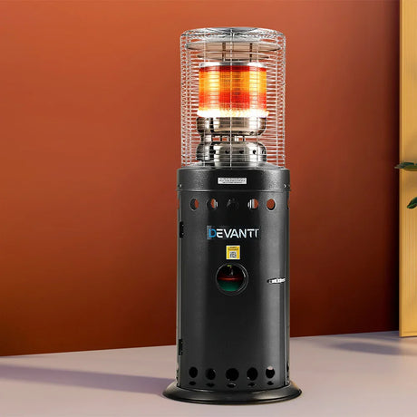 Black outdoor gas patio heater with visible flame and safety grill, standing indoors against a red wall.