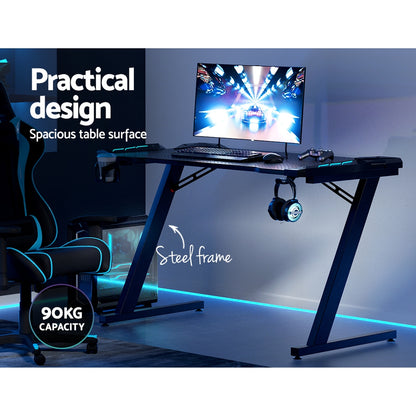 Gaming desk with steel frame, LED lighting, 90kg capacity, spacious surface for monitor, keyboard, and accessories