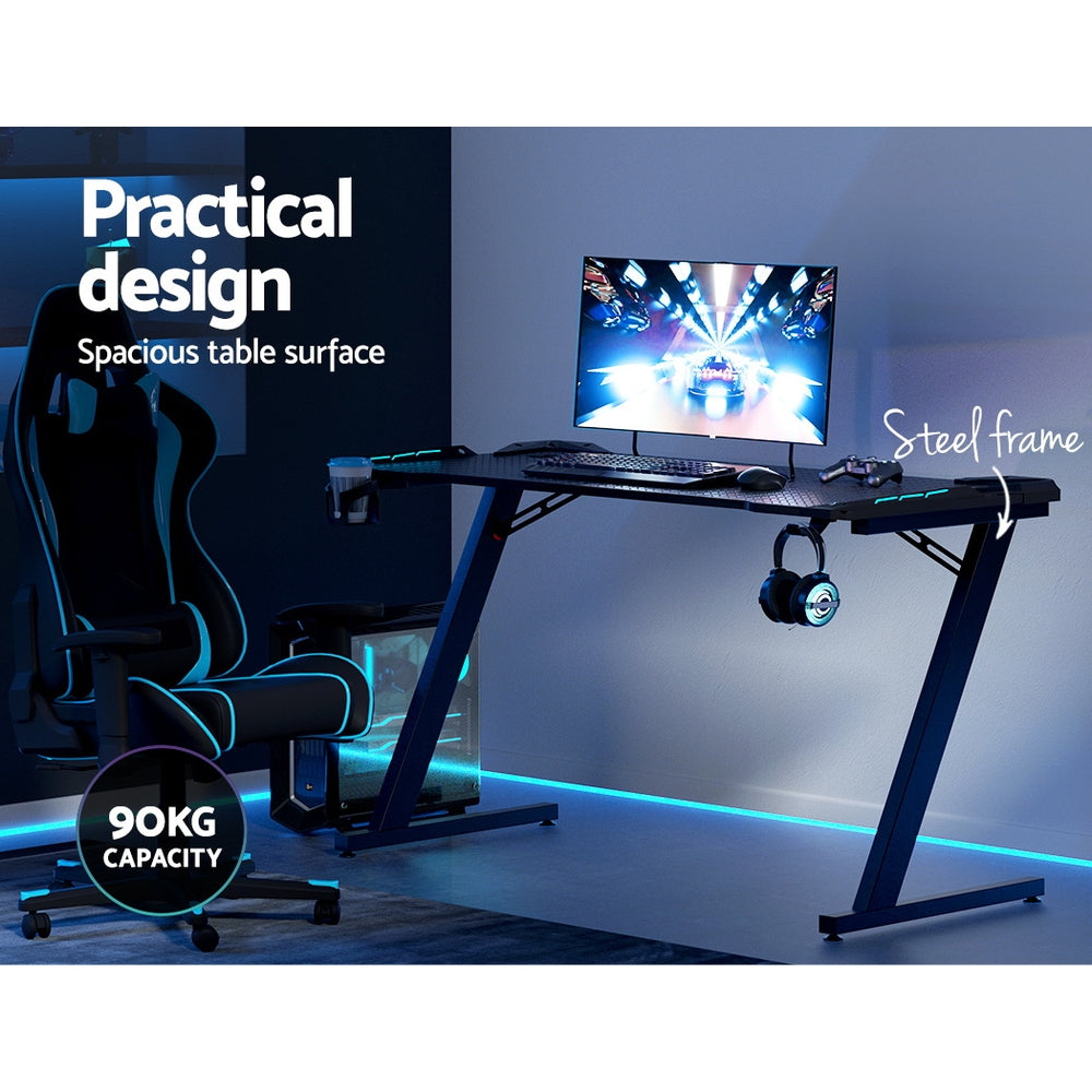 Gaming desk with steel frame, LED lighting, 90kg capacity, spacious surface for monitor and accessories