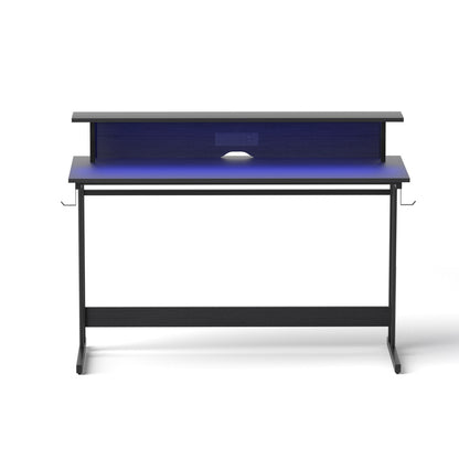 Modern black desk with blue LED backlight and built-in power outlets for home office setup