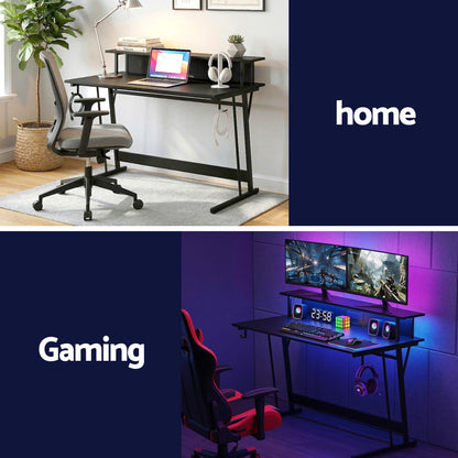 Home office desk with laptop and gaming setup with dual monitors, RGB lighting, and ergonomic chairs