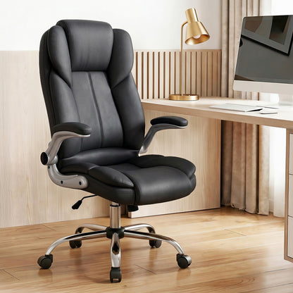 Black leather office chair with adjustable arms, chrome base, and wheels, positioned at a modern desk setup