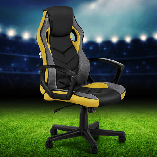 Black and yellow gaming office chair with mesh back, adjustable arms, and 5-wheel base on green turf