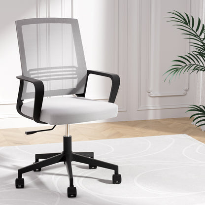 Modern mesh office chair with white cushion, black frame, and rolling casters in a bright room
