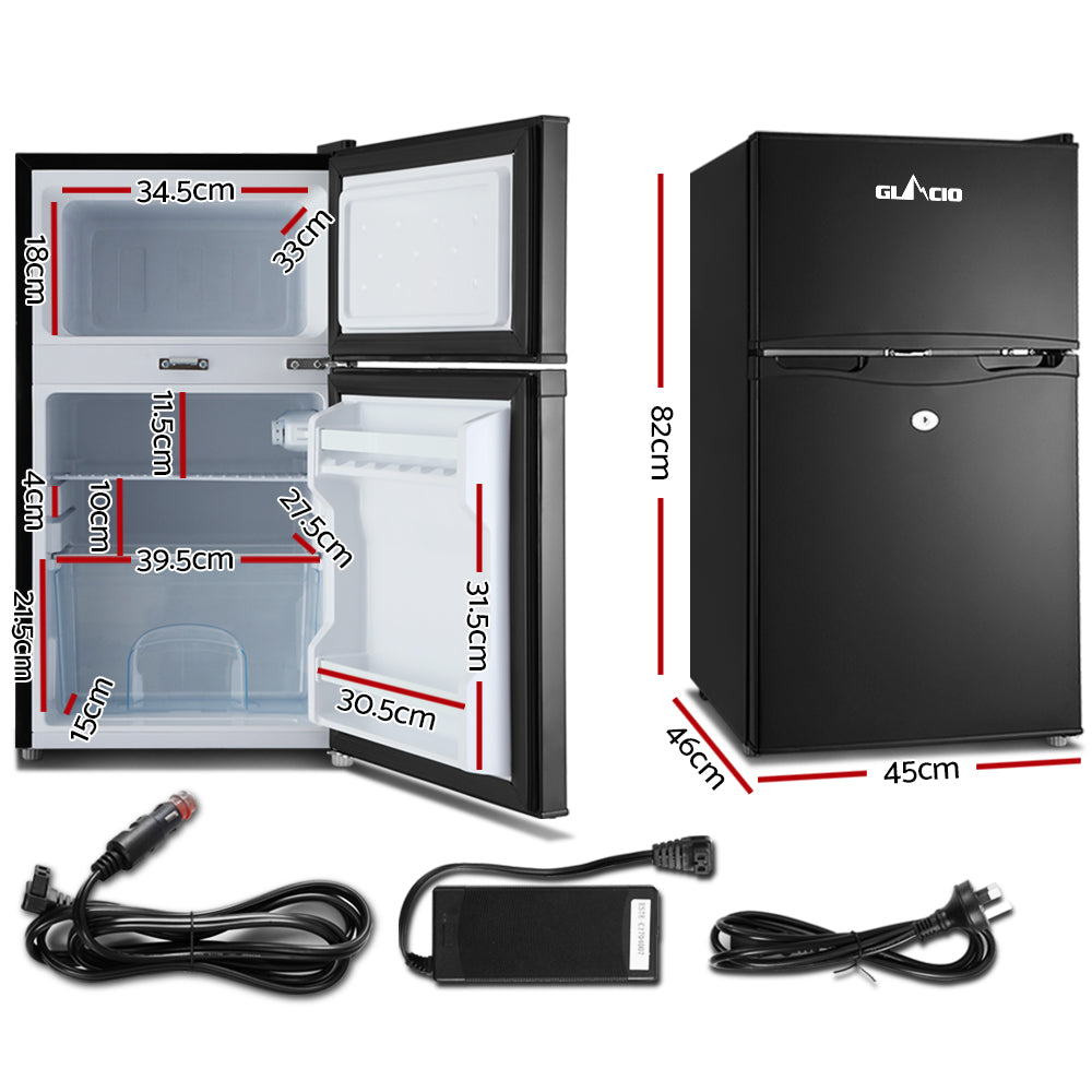 Compact black mini fridge with dimensions, car adapter, and power cords for home or travel use