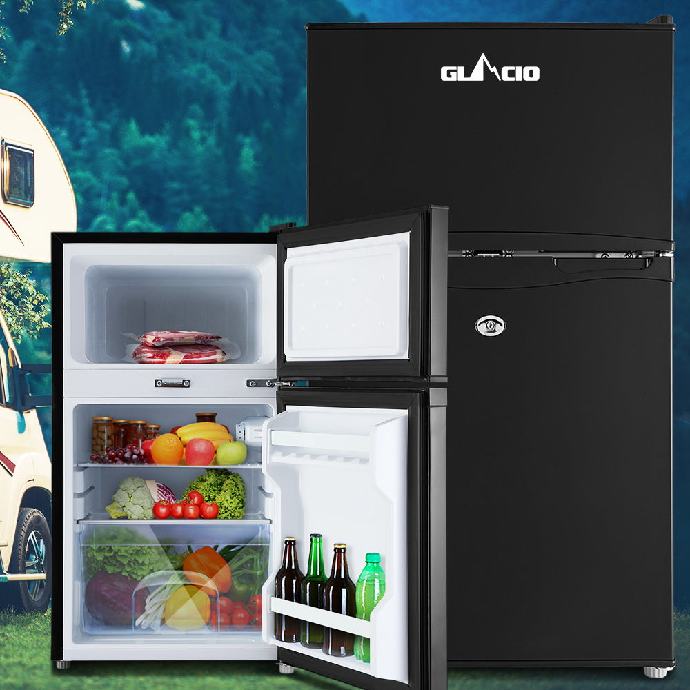 Black Glacio mini fridge with open door, stocked with fresh food and drinks, ideal for camping or small spaces.