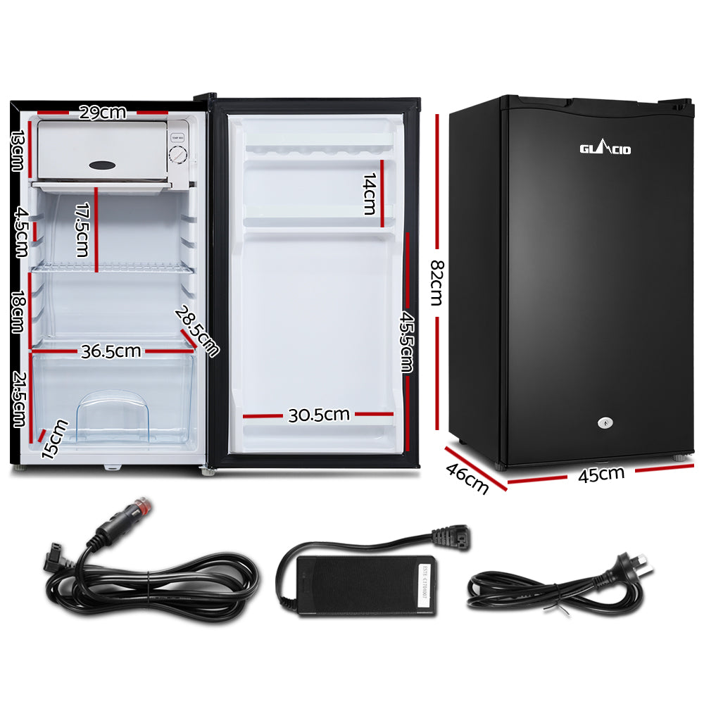 Compact black mini fridge with dimensions, car adapter, power cord, and AC adapter for home or travel use