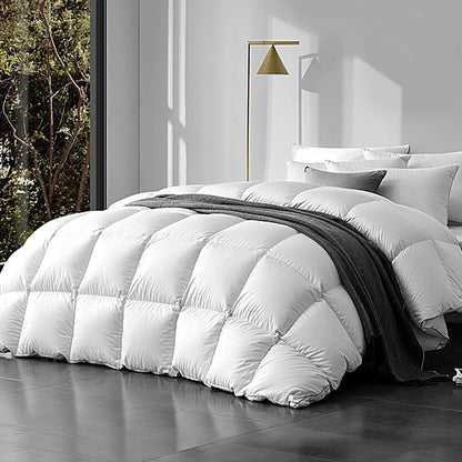 Modern bedroom with white goose down quilt, gray throw blanket, and decorative pillows.