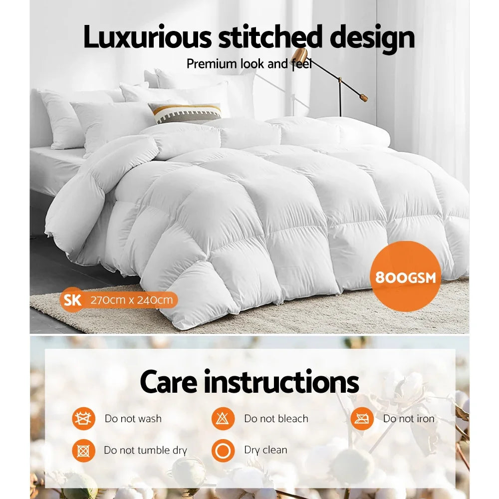 Large white quilted comforter on bed, 800GSM, 270x240cm, with care instructions overlay.