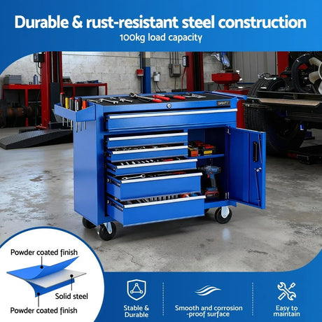 Blue steel tool cabinet with drawers and wheels in a workshop, holding tools and cordless drill