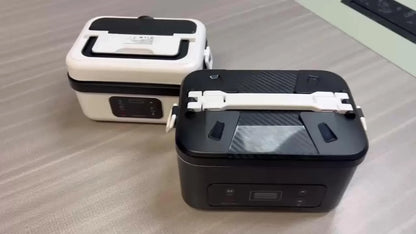 Two portable electric lunch boxes, one black and one white, on a table at Stacks Warehouse AU.