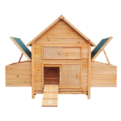 Wooden chicken coop with ramp, nesting boxes, and green roof panels for backyard poultry