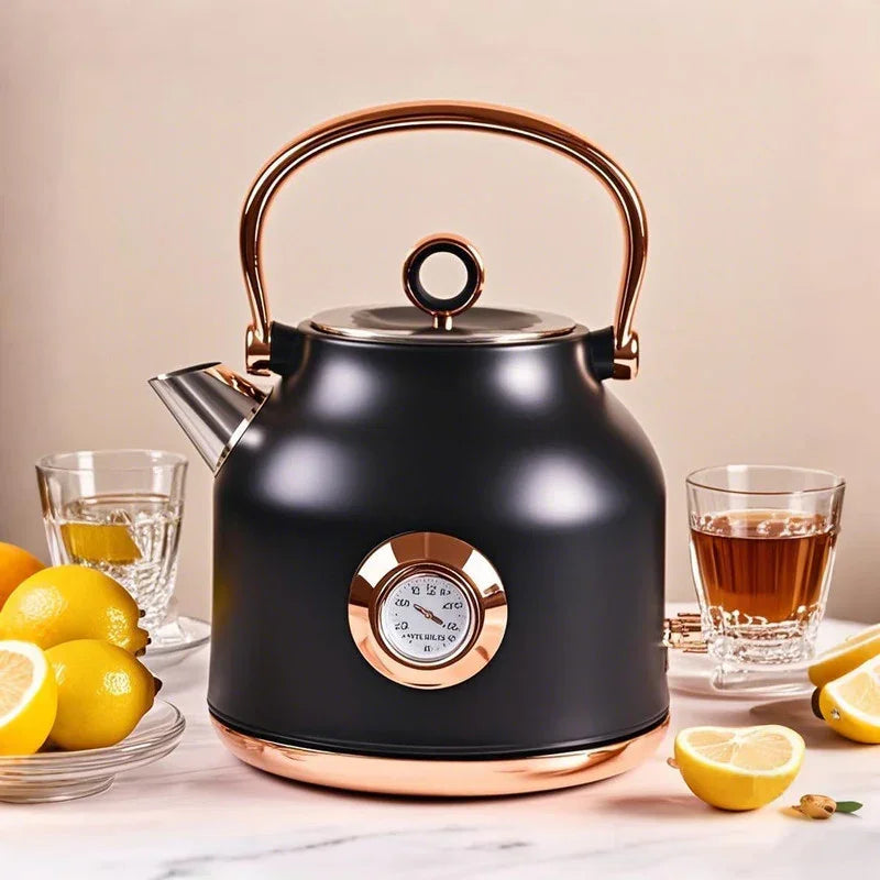 Black electric kettle with copper handle and temperature gauge on kitchen table with lemons and tea glasses