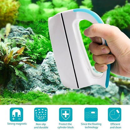 Hand holding a magnetic aquarium glass cleaner brush with blue accents near green aquascape