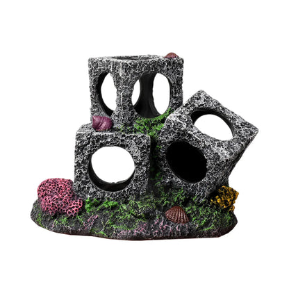 Aquarium decoration with stacked grey stone cubes and colorful corals on a textured base