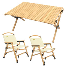 Light wood folding camping table with slatted top and two beige fabric folding camping chairs with wooden frames