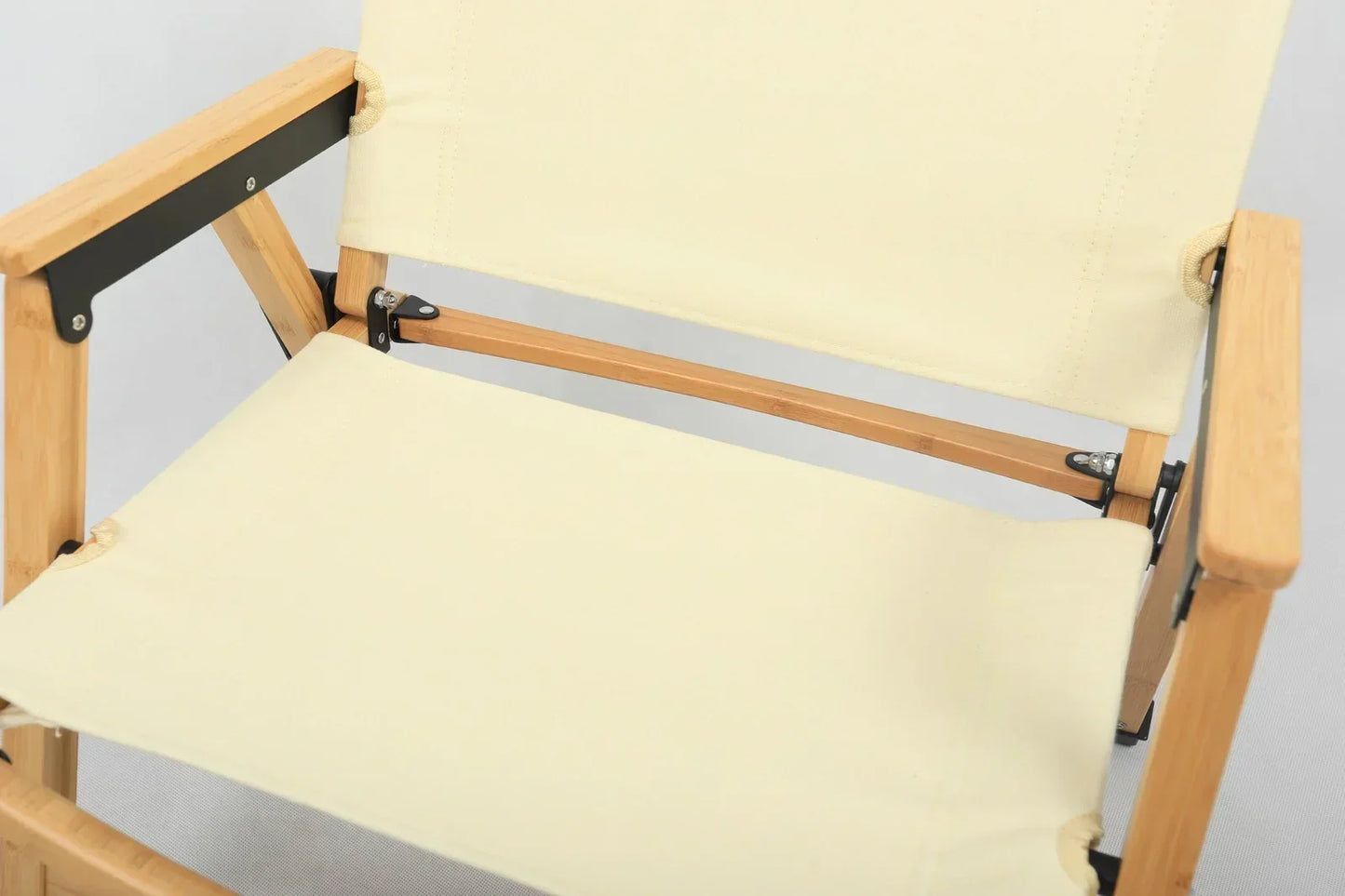 Close-up of beige canvas and bamboo frame director chair with black metal supports